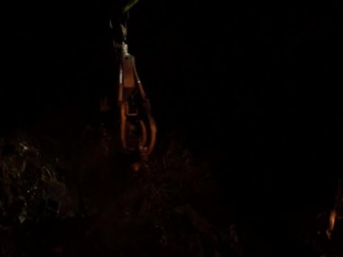 Geceleri büyük bir manipülatörden hurda metal yükleniyor.