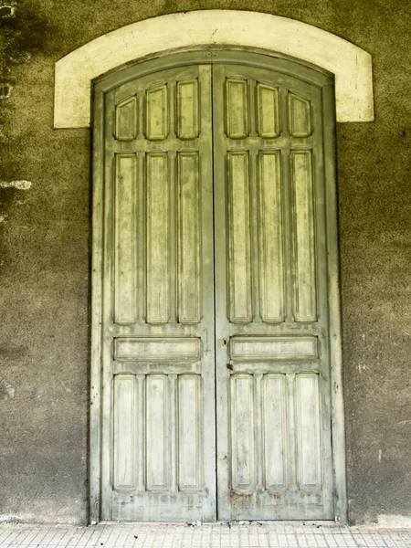 Old high door in green wood