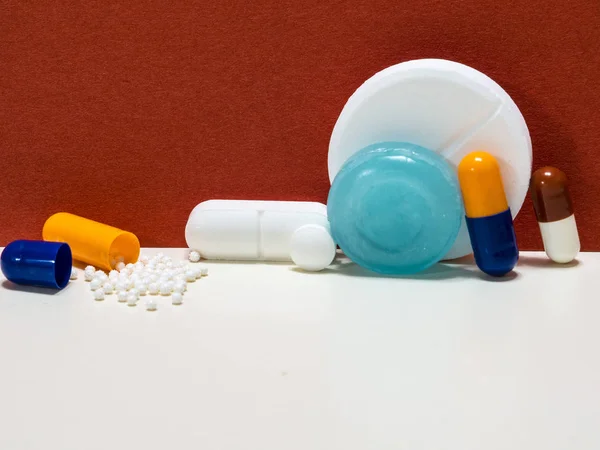 Kapsüller, tabletler ve kırmızı arka plan üzerinde haplar