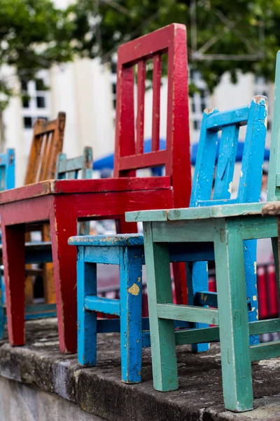 Alineación de sillas de madera de colores de varios tamaños Fotos de stock