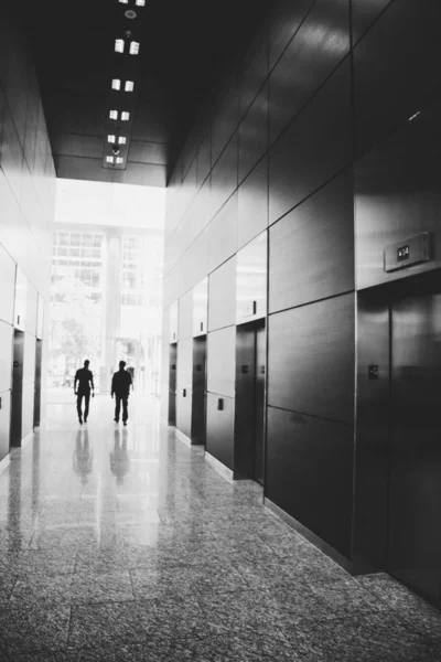 Business people walking away from elevators