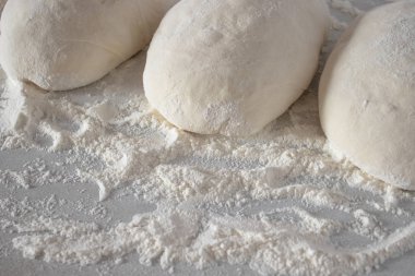 Beyaz masaya izole çiğ hamur topları.