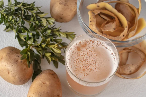 Suyu bir bardak patates ile. Beyaz bir arka plan üzerinde patates.