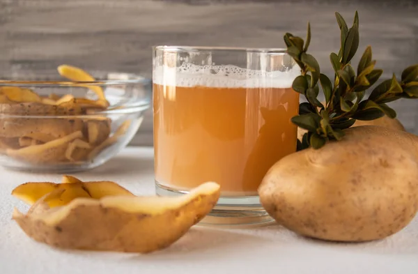 Juice med potatis i ett glas. Skalad potatis. — Stockfoto