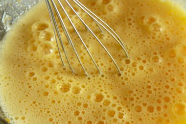 Beat yumurta yumurta close-up bir cam kavanoza.