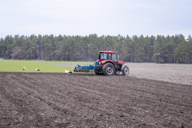 Bir çiftçi bir traktör üzerinde toprak Kültüvatör ile hazırlar. Tarımsal alanların Ekim.