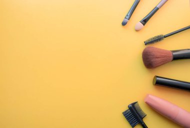 Makyaj Fırçalar, günlük makyaj için fırçalar. Sarı arka planda kozmetik öğeleri, closeup.
