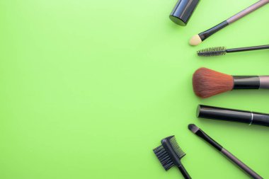 Makyaj Fırçalar, günlük makyaj için fırçalar. Yeşil arka planda kozmetik detayları, çekim.