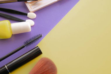 Kozmetik aksesuarları. Sarı, mor arka planda allık, fırça, vernik için fırça.