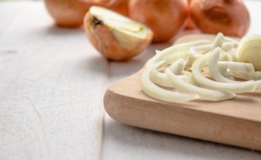 Ahşap arka plan üzerinde dilimlenmiş taze soğan. Sağlıklı bir diyet için sebzeler. Vegan gıda.
