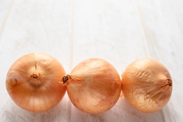 Fresh onions on wooden background. Vegetables for a healthy diet. Vegan food.