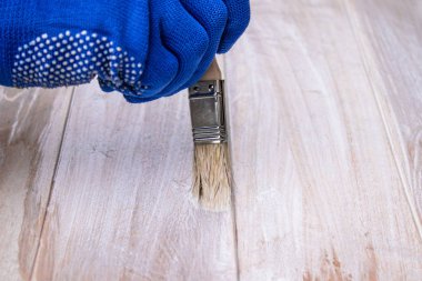 Adam beyaz boya yüzeyi boyuyor. Boyama panoları.