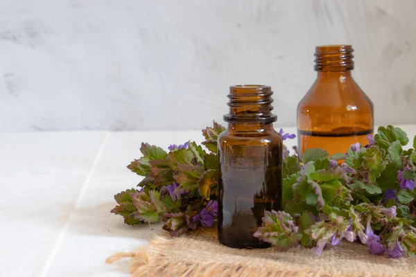 Essential aromatic oil with flowers on wooden background. Selective focus. — Stock Photo, Image