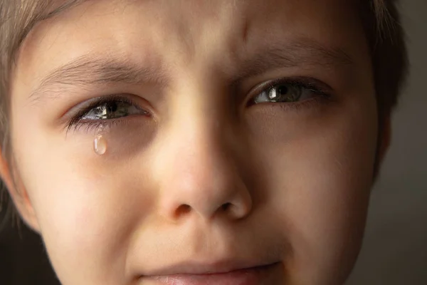 Lágrimas en los ojos de un niño. Una lágrima en la mejilla del chico . — Foto de Stock