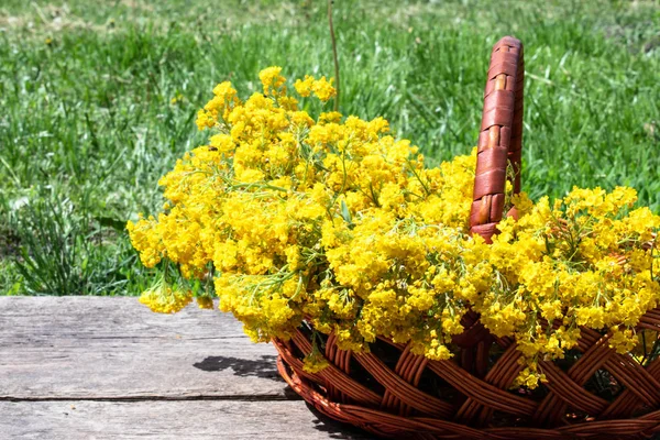 Un ramo de pequeñas flores amarillas en una canasta de madera sobre tablas viejas . —  Fotos de Stock