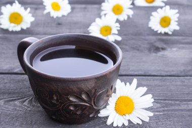 Ahşap arka plan üzerinde papatya çayı ve papatya çiçekleri Fincan.