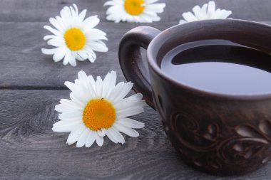 Ahşap arka plan üzerinde papatya çayı ve papatya çiçekleri Fincan.