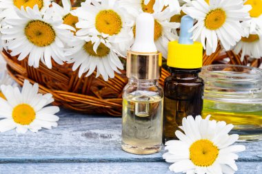 Bir cam kavanoz ve papatya yakın bir şişe papatya uçucu yağ.