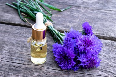 ahşap bir arka plan üzerinde cornflower uçucu yağ.