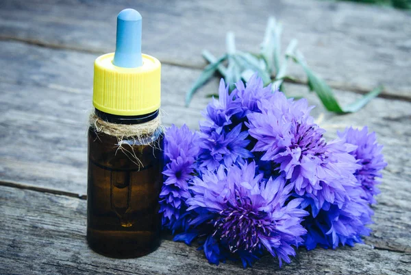 Cornflower essential oil on a wooden background. — Stock Photo, Image