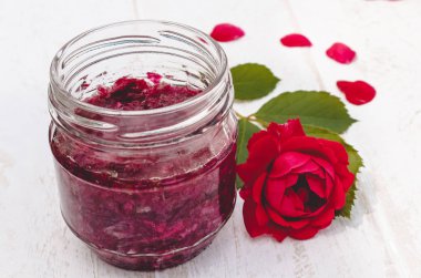 Hafif bir arka plan üzerinde cam bir kavanozda gül yaprakları Reçel. Çiçek sırı. Sağlıklı gıda.