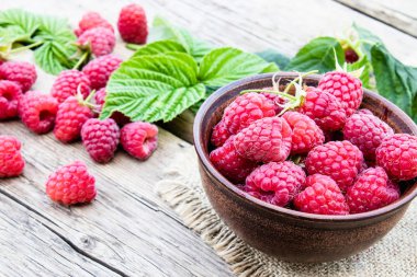 Eski kurulların arka planda bir kase üzerinde olgun kırmızı ahududu. Seçici odaklama.