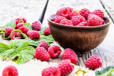 Eski kurulların arka planda bir kase üzerinde olgun kırmızı ahududu. Seçici odaklama.