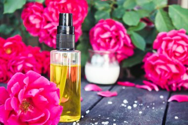 Koyu ahşap arka plan üzerinde Gül uçucu yağ closeup.