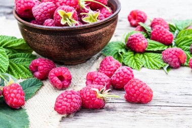 Eski kurulların arka planda bir kase üzerinde olgun kırmızı ahududu. Seçici odaklama.