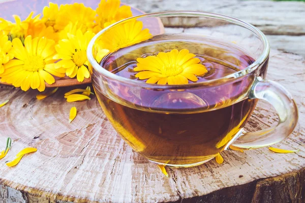 Травяной чай из цветов календулы в прозрачной стеклянной кружке. Экстракт настойки календулы в чашке . — стоковое фото