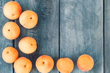 Ahşap bir masada olgun sarı kayısı yalan.