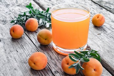 Eski tahtaları arka planda kayısı ve yeşil nane dalları ile taze kayısı suyu.