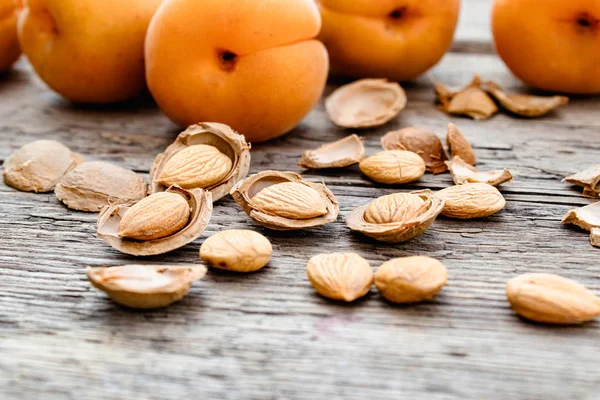 Apricot and apricot seeds on the background of old boards. Apricot pits for the manufacture of tablets and drugs. — Stock Photo, Image