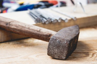 Tahtaların arka planında çiviolan eski çekiç. İnşaat işleri için araçlar.