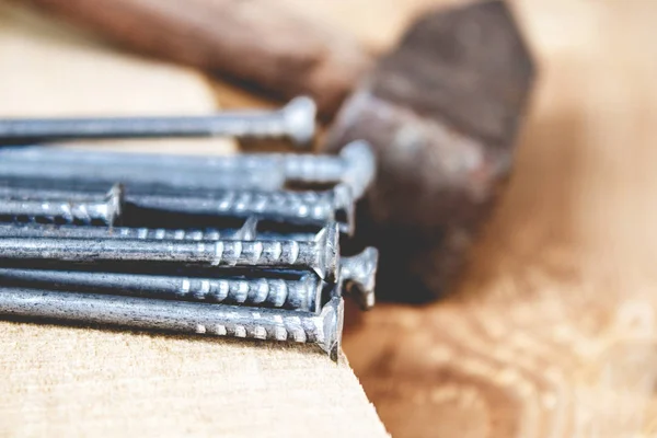 Old hammer with nails on the background of boards. Tools for construction work.