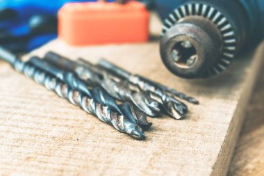 Ahşap bir arka plan üzerinde güç matkap yakınında Matkaplar. Alet ve onarım işleri kavramı.