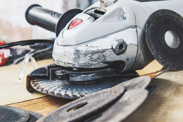 circles for the angle grinder are on wooden boards near the grinder.