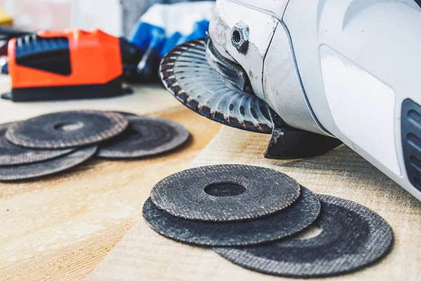 circles for the angle grinder are on wooden boards near the grinder.