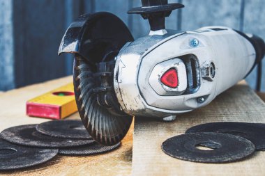 Elektrikli kesme ve öğütme makinesi. Ahşap tahtalarda aşındırıcı diskli açı öğütücü.