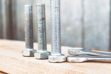 Çelik somun cıvata ve yıkıtakanlar ahşap tahtalar üzerinde yalan.