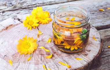 Calendula officinalis taze bir bitki ile Calendula tentür şeffaf kavanoz. Calendula tentürü özü.