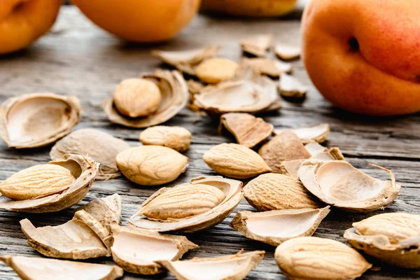 Eski panoların arka planında çukurlara yakın kayısı ve kayısı çukurları. Tablet ve ilaç üretimi için kayısı çukurları.