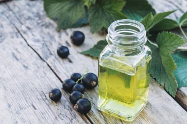 Özü ile cam şişe yakınında siyah frenk üzümü Taze çilek. Siyah frenk üzümü ile Tıbbi tentür.