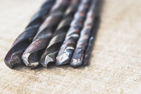 Ahşap bir arka plan üzerinde matkaplar. Alet ve onarım işleri kavramı.