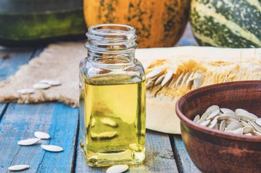 Kabak çekirdeği ve uçucu yağ mavi eski panoları kabak yakın bir şişede.