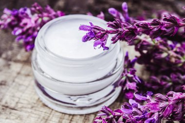 Lavanta kır çiçekleri ile ahşap bir arka plan üzerinde cam bir kavanozda Kozmetik krem. Yüz kremi.