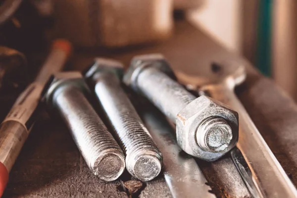 Tools for the job. Bolts and nut with wrench are on the table.