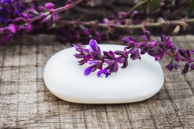 Lavanta kır çiçekleri ile ahşap bir arka plan üzerinde el yapımı lavanta sabun. Vücut bakımı.