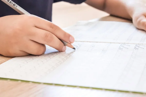 School jongen schrijven close-up. Potlood in de hand van kinderen. — Stockfoto