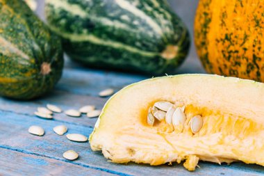 Olgun turuncu kabak mavi eski tahtalarda tohumları ile dilimlenmiş.